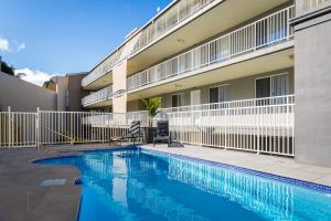 a swimming pool in front of a building at Albacore Apartments in Merimbula