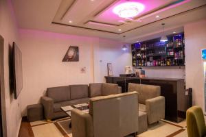 a living room with a couch and a bar at Abada Luxury Hotel and Suites in Onitsha