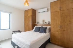 1 dormitorio con 1 cama grande y armario de madera en Viñedos del Mar en Ensenada