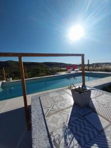 a patio with a view of a swimming pool at Agave Serrano in Villa Rumipal