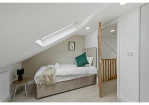 a bedroom with a bed with white sheets and green pillows at Serenity, Scenery, Shopping, & Sports in London