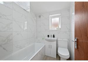 ein weißes Bad mit einem WC und einem Waschbecken in der Unterkunft Serenity, Scenery, Shopping, & Sports in London