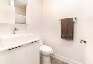 a white bathroom with a toilet and a sink at One bedroom apartment - 507 in Montreal