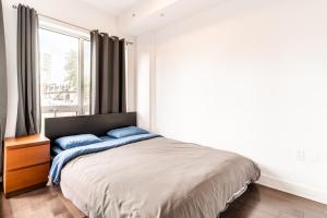 a bedroom with a bed with a large window at One bedroom apartment - 507 in Montreal