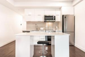 a kitchen with white cabinets and a refrigerator at One bedroom apartment - 507 in Montreal