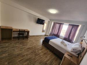 una camera d'albergo con letto e scrivania di HOTEL LUXOTEL PISCO a Pisco