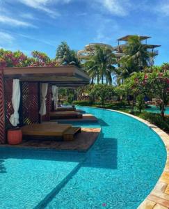 a large swimming pool with a building in the background at Hot Beach Suites in Olímpia