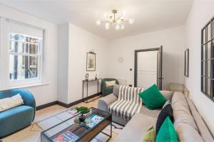 a living room with a couch and a table at Trendy 3-Bedroom Hackney Pad in London