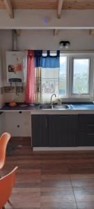 a kitchen with a sink and two windows at Tu-maci2 in Ushuaia +4 photos