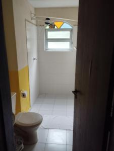 a bathroom with a toilet and a window at Rancho do Edy Pousada in São Roque
