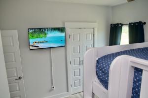 a bedroom with a bed and a tv on a wall at Peaceful Shores Retreat in Panama City Beach