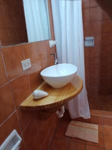 La salle de bains est pourvue d'un lavabo sur une table en bois. dans l'établissement Arica Surf & Beach House, à Arica