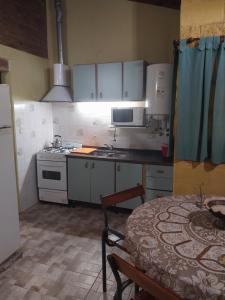 une cuisine avec des armoires blanches, une table et une cuisinière dans l'établissement La Soñada, à La Granja