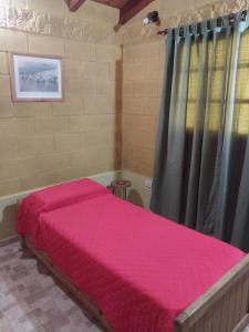 - une chambre avec un lit rose dans l'établissement La Soñada, à La Granja