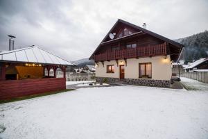 dom z pokrytym śniegiem podwórkiem przed nim w obiekcie Chata Schwarzbach Osrblie w mieście Osrblie