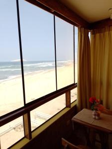 Habitación con ventana y vistas a la playa. en Arica Surf & Beach House, en Arica
