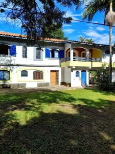 a large white house with a yard at Rancho do Edy Pousada in São Roque