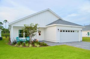 a white house with a garage at Peaceful Shores Retreat in Panama City Beach