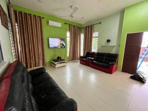 sala de estar con sofá y TV de pantalla plana en Homestay Ustaz Free Internet WiFi Android TV, en Pekan