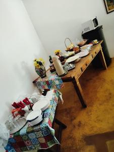 a table with plates on it in a room at Rancho do Edy Pousada in São Roque