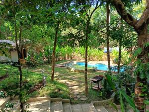 a swimming pool in the middle of a yard with trees at Kawai Duli Bungalows 1 in Duli