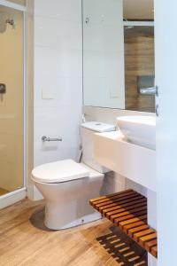 a white bathroom with a toilet and a sink at Flat Ocean View in Rio de Janeiro