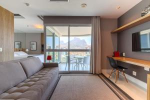 a living room with a couch and a large window at Flat Ocean View in Rio de Janeiro