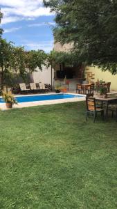 a yard with a table and chairs next to a pool at Posada del vino in Maipú