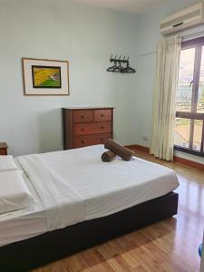 a bedroom with a bed and a dresser and a window at Town Condo - Marina Court Kota Kinabalu in Kota Kinabalu
