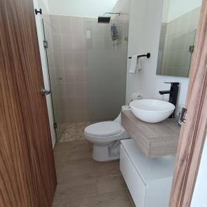 y baño con aseo blanco y lavamanos. en RIBERA DE CHAPALA Suites, en Chantepec