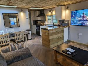 a kitchen and living room with a tv on the wall at The Lodge 