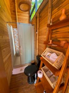 a bathroom with a toilet in a wooden cabin at NaturalMente Glamping in San Antonio del Tequendama