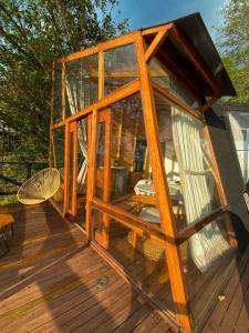 uma grande casa de vidro num deque de madeira em NaturalMente Glamping em San Antonio del Tequendama