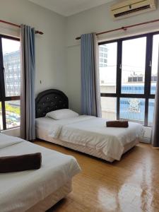 コタキナバルにあるTown Condo - Marina Court Kota Kinabaluの大きな窓のある部屋にベッドが2つある