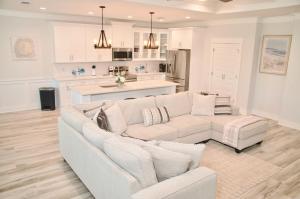 a living room with a white couch and a kitchen at Peaceful Shores Retreat in Panama City Beach