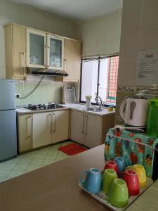 a kitchen with a table with colorful mugs on it at Town Condo - Marina Court Kota Kinabalu in Kota Kinabalu