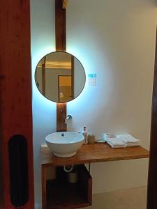 a bathroom with a sink and a mirror at Kawai Duli Bungalows 1 in Duli