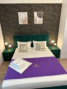 1 dormitorio con 1 cama con 2 toallas en DEKO Apartments & Studios Near Palas Mall en Iaşi