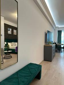 Habitación con espejo, cama y sala de estar. en DEKO Apartments & Studios Near Palas Mall en Iaşi