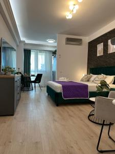 una camera con letto, tavolo e sedie di DEKO Apartments & Studios Near Palas Mall a Iaşi