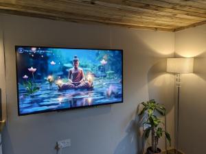 telewizor z płaskim ekranem wiszący na ścianie w obiekcie The Lodge 