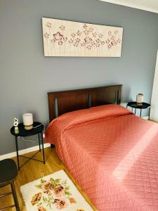 um quarto com uma cama vermelha e duas mesas em Casa das Courelas em Nordeste