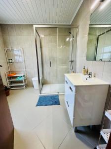 uma casa de banho com um chuveiro e um lavatório. em Casa das Courelas em Nordeste