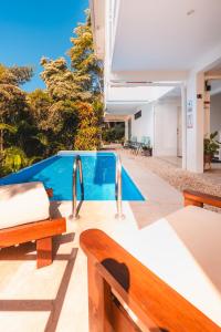 a swimming pool with a bench and a swimming pool at Buena Vista Ocean View Apartments Santa Teresa in Santa Teresa Beach