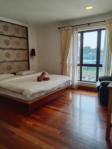 a bedroom with a bed with a person laying on it at Town Condo - Marina Court Kota Kinabalu in Kota Kinabalu