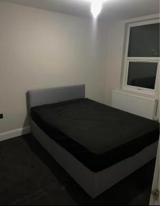 a bed in a room with a window at Double Bedroom in London