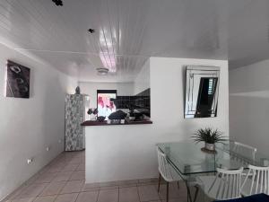 a dining room with a glass table and white walls at SIMPLISSIME T4 à KOUROU in Kourou