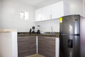 a kitchen with a refrigerator and wooden cabinets at APARTAMENTO VALLEDUPAR in Valledupar