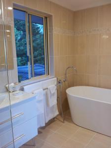 a bathroom with a tub and a sink and a window at Waterview Gardens B&B in Margate