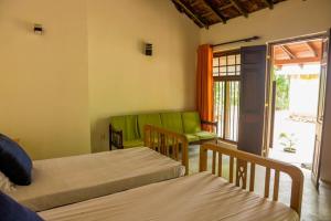 1 dormitorio con 2 camas y sala de estar en Villa Milla Walauwa, en Matale